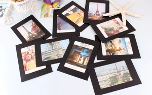 Detail of black paper frames with vintage art prints, rope clips and decorative props