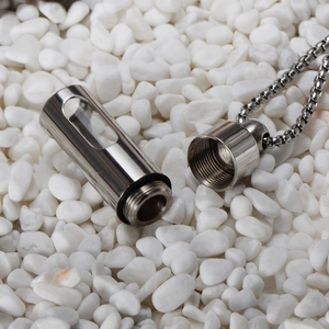 Detail of capsule aroma pendant showing the screw cap and clear glass window on steel chain