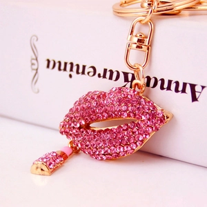 Sparkling pink rhinestone red lips keychain with lipstick pendant on a white book