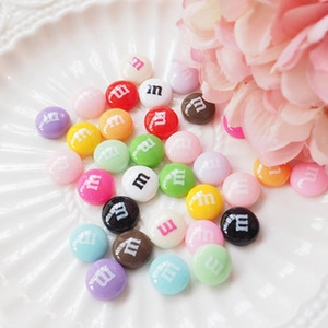 Close-up of colorful resin heart patches with glitter finish on a white wavy plate