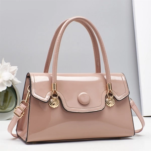 Elegant light pink patent leather handbag with gold metal clasp and minimalist floral background