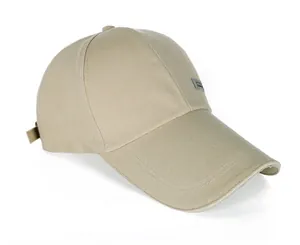 Detail view of khaki canvas baseball cap featuring a metal logo and reinforced stitching