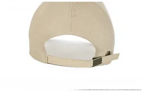 Macro detail of beige baseball cap featuring adjustable dark metal back buckle