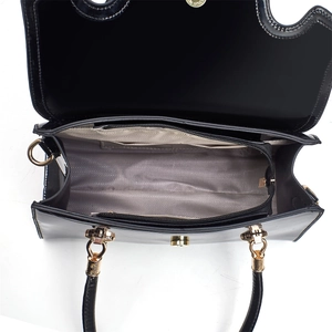 Detailed top view of black patent leather handbag interior with grey herringbone lining
