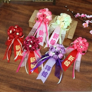 Dettaglio di corsage di rose in seta con nastri per l'identificazione degli sposi