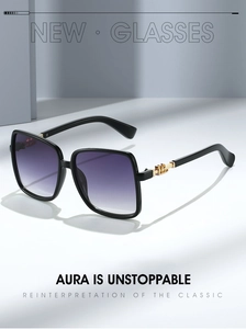 Detail of square black frame sunglasses with purple gradient lenses and gold metal accents