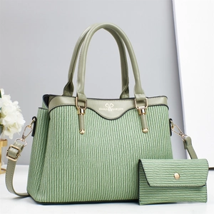 Detail view of light green pleated leather tote bag with matching coin purse and gold hardware