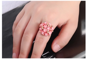 Close-up of pink flower cluster ring with rhinestones worn on a finger