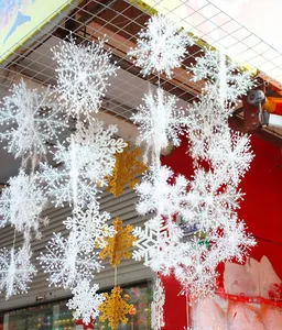 Detail of hanging white and gold glitter snowflake ornaments in festive holiday patterns