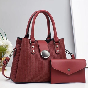 Détail du cabas bordeaux texturé et de la pochette avec boucle en métal argenté
