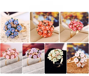 Detailed close-up of handmade ceramic flower rings in seven vibrant colors with rhinestones