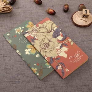 Retro floral kraft paper notebooks in green and orange with artistic vintage cover text