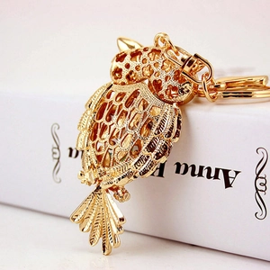 Golden owl keychain with rhinestone inlay for women bag accessory on white book