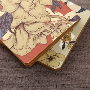 Close-up of vintage floral pattern paper covers on stacked kraft notebooks