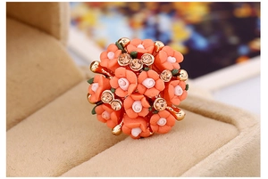 Detailed macro of a floral ring featuring resin flowers and rhinestones in a velvet box