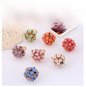 Detailed overhead shot of seven colorful floral resin rings with golden micro-drills