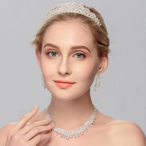Detailed view of elegant silver crown, necklace, and earrings set with crystal rhinestones