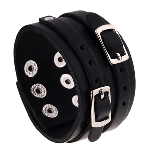 Détail macro du bracelet punk large en cuir noir avec doubles boucles et clous argentés