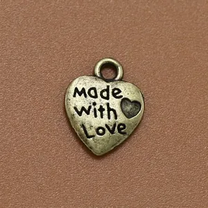 Colgante de corazón en bronce antiguo con grabado "Made with Love" sobre fondo de cuero