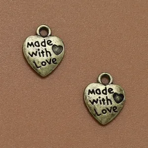 Par de colgantes vintage de metal en forma de corazón con grabado 'Made with Love' para DIY
