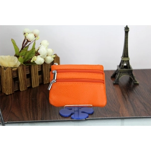 Detail of orange genuine leather mini wallet with three silver zippers and lychee texture