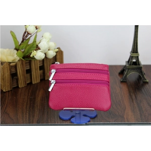 Detail view of rose red pebble leather coin purse with three silver zipper compartments