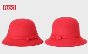 Detailed close-up of red wool felt cloche hat featuring a decorative bow on the brim