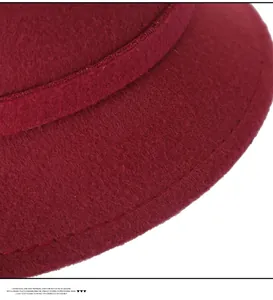 Detailed macro view of burgundy wool felt hat showing stitching and premium texture