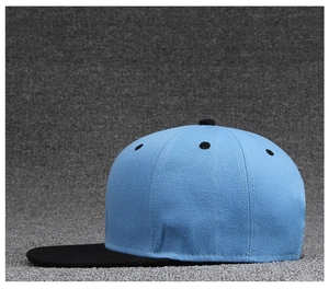 Detail view of two-tone flat brim baseball cap featuring light blue crown and black visor