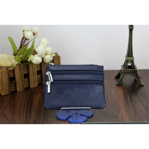 Close-up of deep blue litchi leather coin purse with triple silver zippers on blue stand