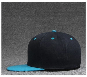 Detail of a two-tone flat brim baseball cap with teal visor and black cotton crown