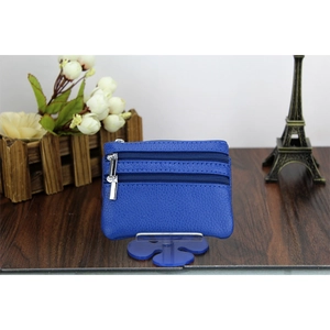 Close-up of blue genuine leather coin purse with double zippers on a wooden table setup