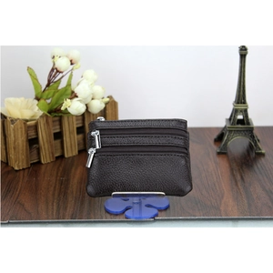 Detail of dark brown leather coin purse with three zipper compartments and lychee texture