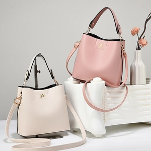 Detail of pink and beige bucket bags with lychee grain leather and gold hardware