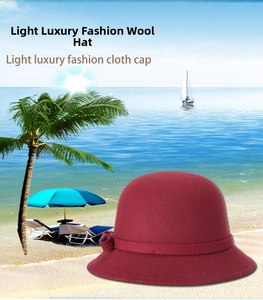 Close-up of a burgundy wool felt bucket hat featuring a vintage bow knot decoration