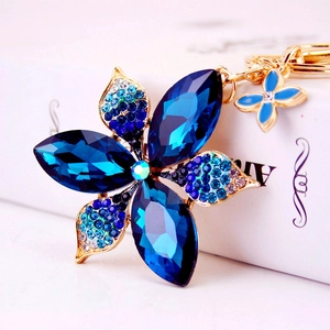 Funkelnder Kristall Blumen Schlüsselanhänger mit blauen Strasssteinen und Schmetterling