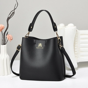 Close-up of black litchi grain leather bucket bag with gold logo and hardware