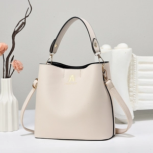 Elegant cream leather bucket bag with top handle and adjustable shoulder strap