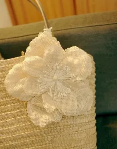 Straw woven tote bag featuring a large white mesh flower detail in pastoral style