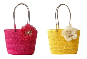Detail of straw woven handbags with mesh floral accents and round top handles
