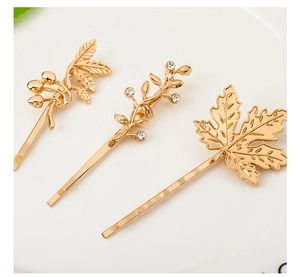 Detail of three gold leaf hairpins with berry accents and crystal rhinestones