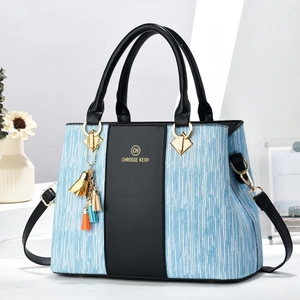 Chic black and striped shoulder bag with tassel charm and detachable strap