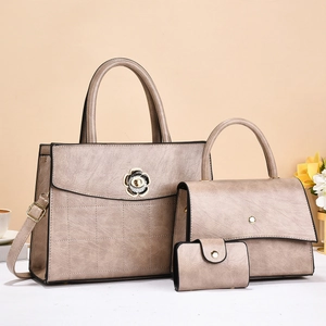Detailed view of champagne leather handbag set with floral clasp and textured finish