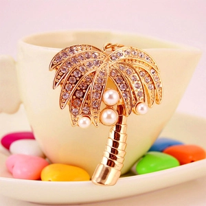 Golden palm tree keychain with sparkling rhinestones and white pearls on a heart-shaped cup
