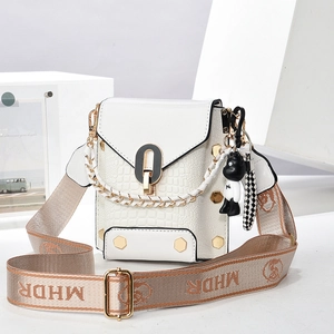 Close-up of white crocodile pattern mini bag with U-shaped gold buckle and panda charm