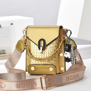 Detail of gold faux crocodile mini bag with metal lock, chunky chain, and panda charm