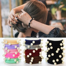 Detail view of colorful elastic hair bands with pearls including black and pink styles