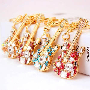Golden guitar keychains with colorful rhinestones on a white box for music lovers