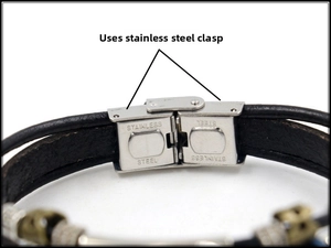 Macro shot of stainless steel clasp with engraved text on black leather bracelet