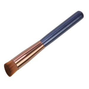 Detailed close-up of flat head foundation brush with rose gold ferrule and brown bristles